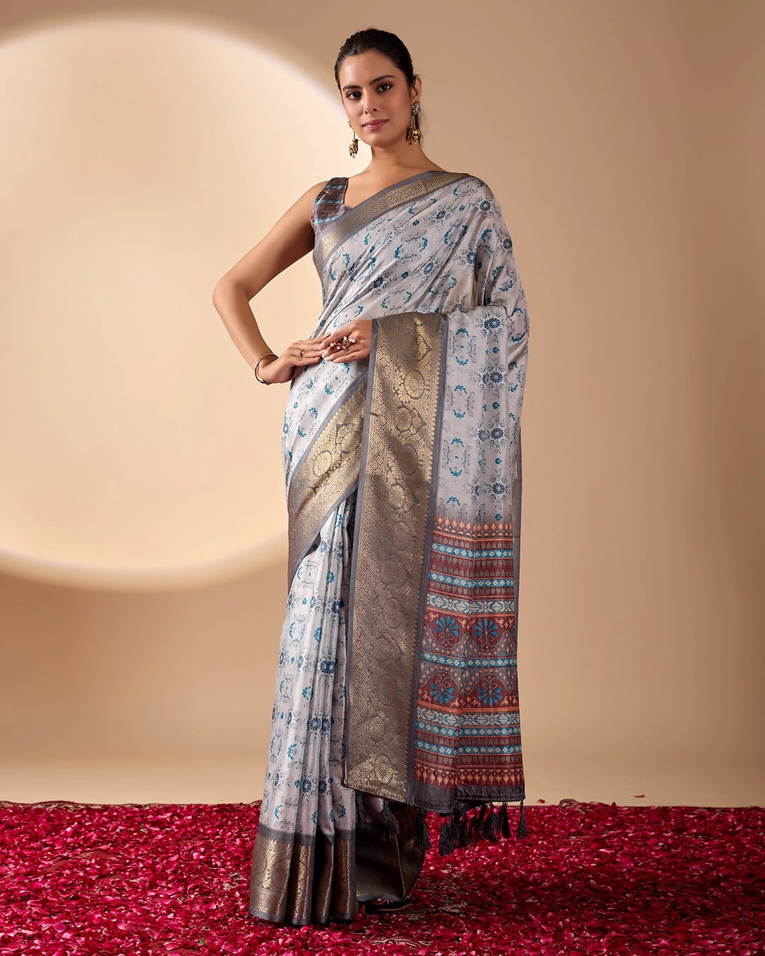 Woman wearing a traditional saree with a patterned design on a beige background
