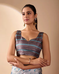 Woman wearing a patterned top with a plain background