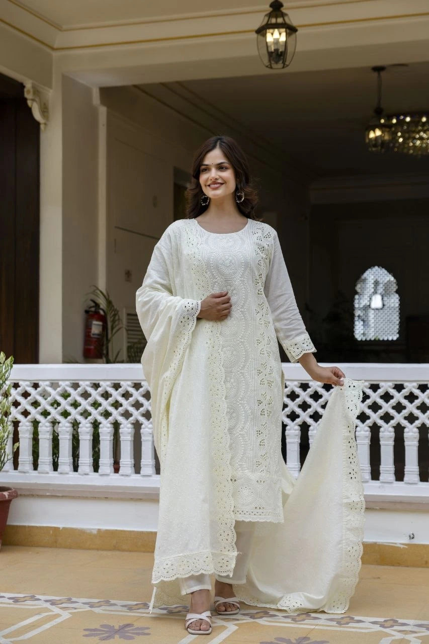 Woman in a white traditional outfit standing on a balcony.