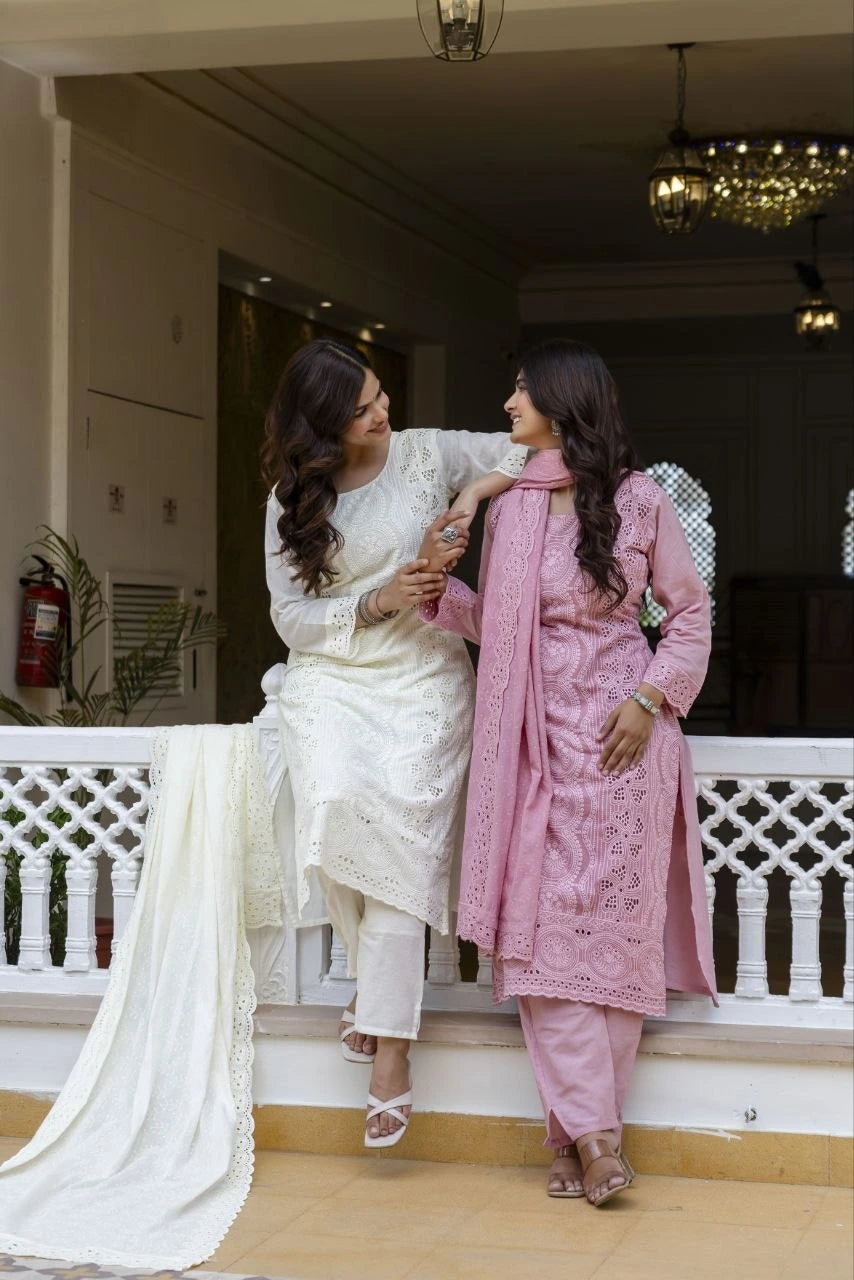 Two women in traditional attire sitting on a staircase indoors.
