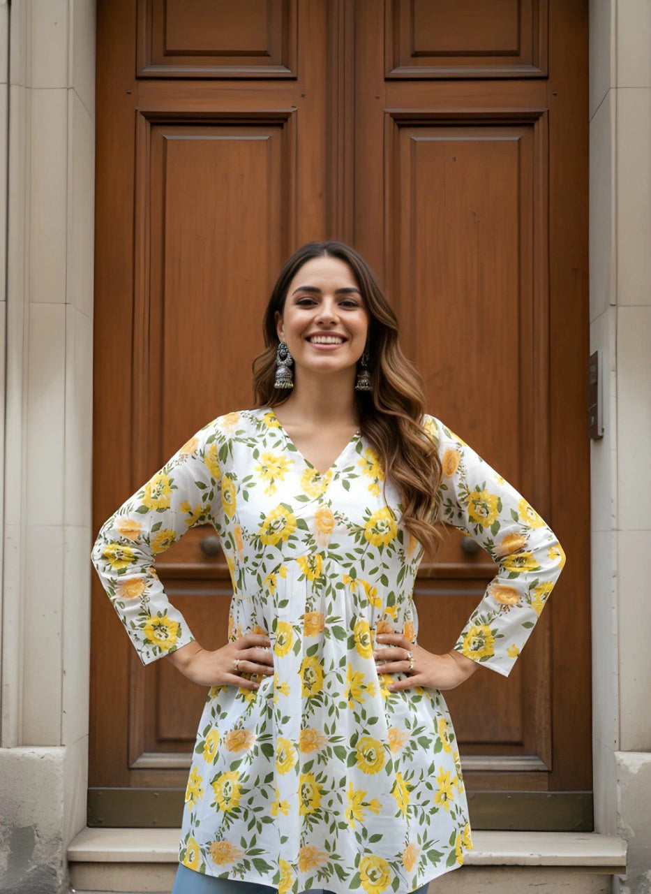 Woman wearing a floral blouse standing in front of a wooden door.