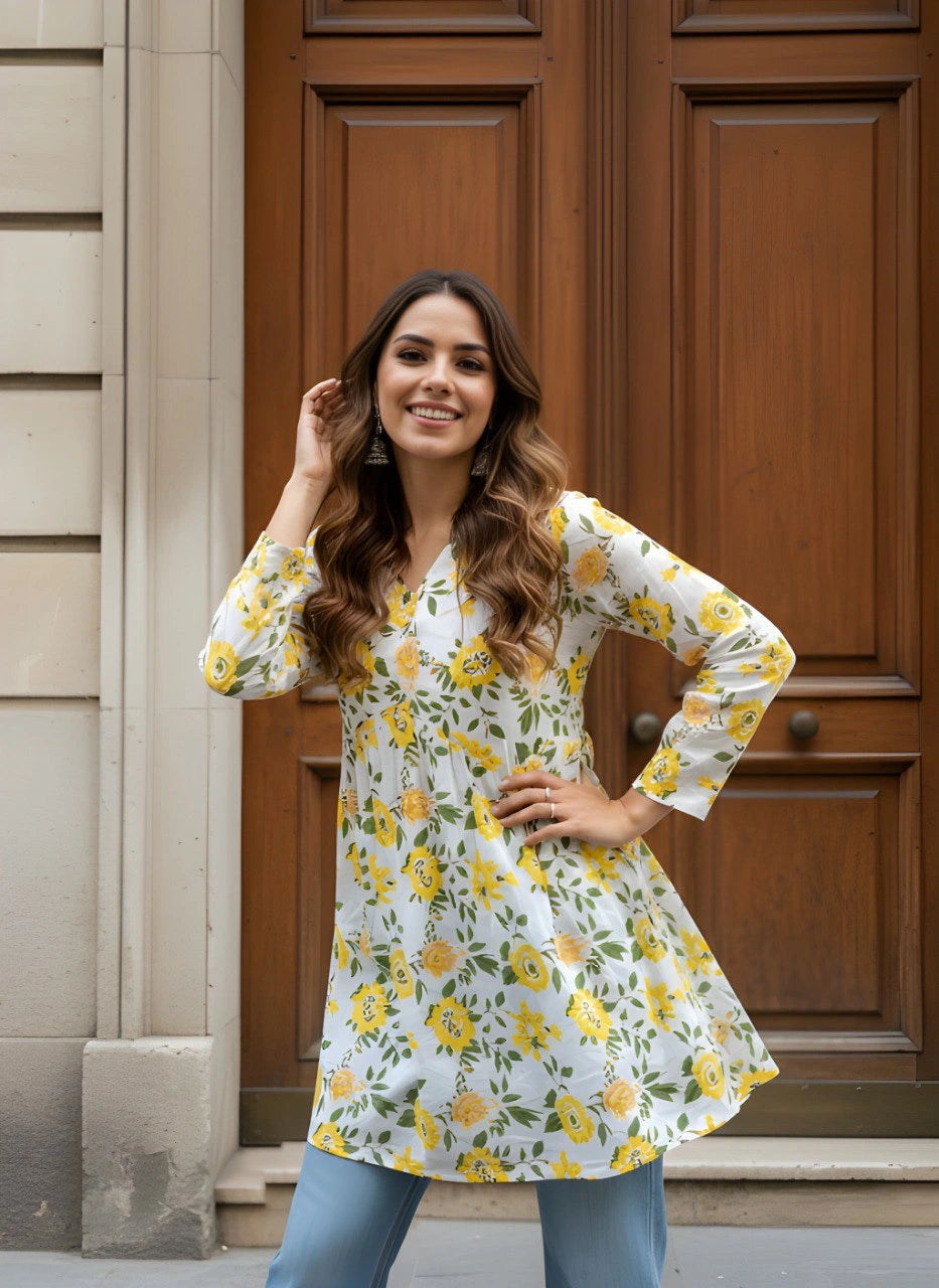Woman wearing a floral dress standing in front of a wooden door.