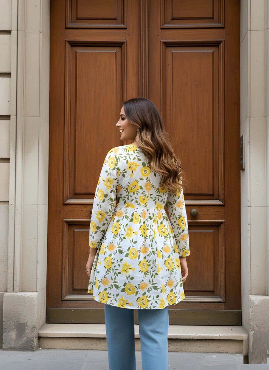 Woman wearing a floral dress standing in front of a wooden door.