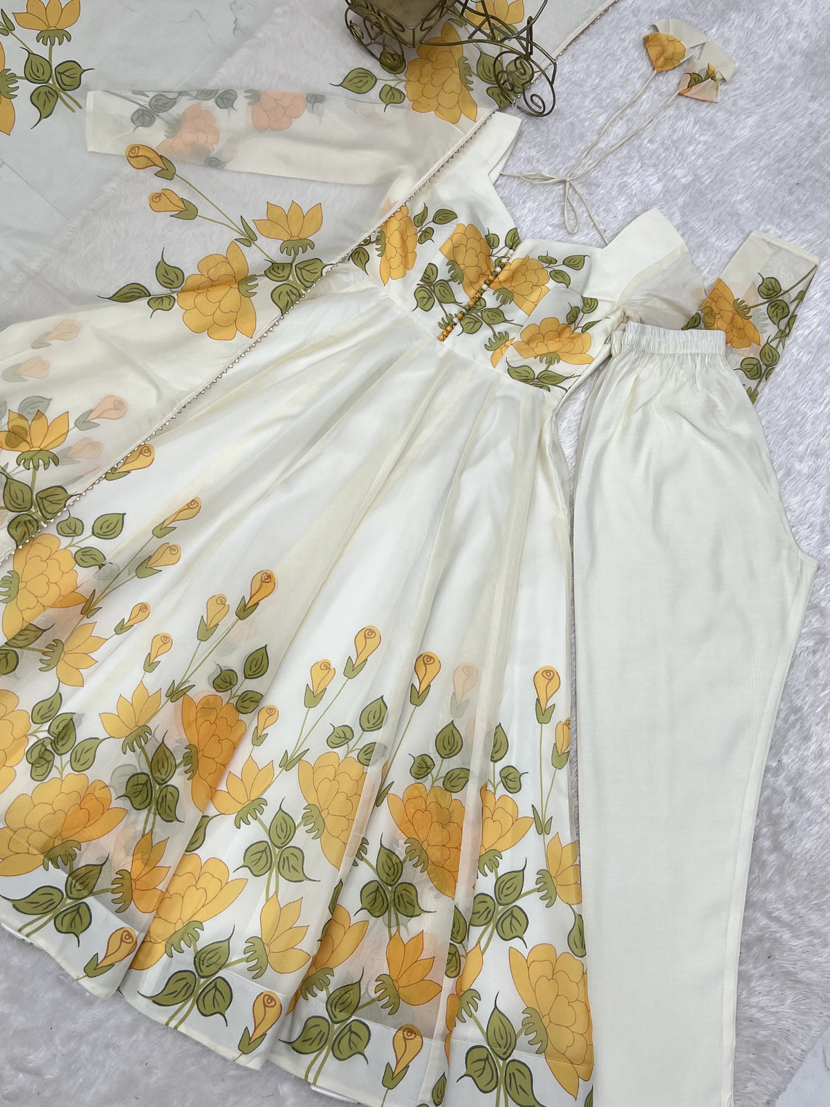 White dress with yellow floral pattern on a light gray background