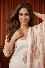 Woman in traditional outfit with floral patterns against a warm-toned background