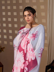 Woman wearing a floral saree with a pink and white design against a neutral background