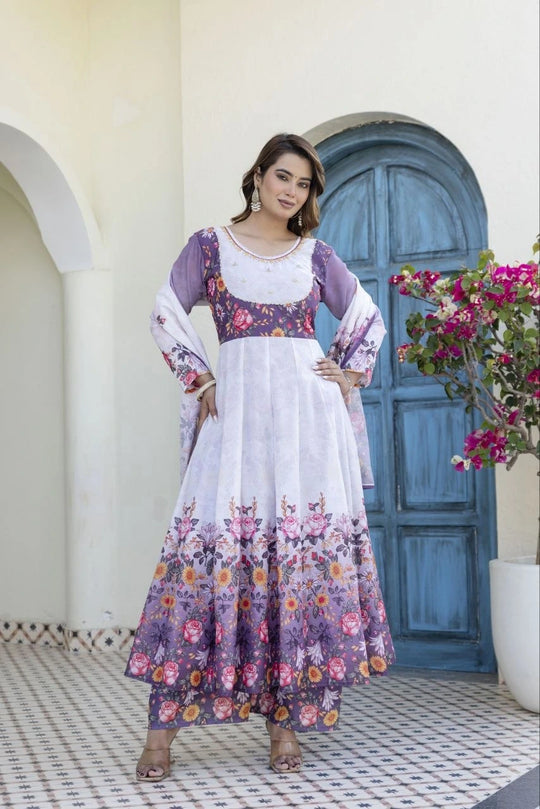 Woman wearing a lavender floral Anarkali suit with matching printed pants and a soft organza dupatta featuring elegant tassel details.