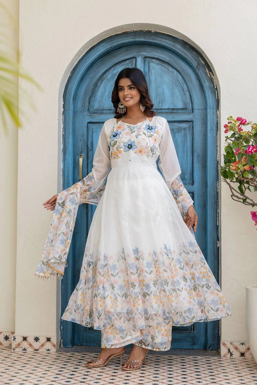 Woman in a floral dress standing in front of a blue door.
