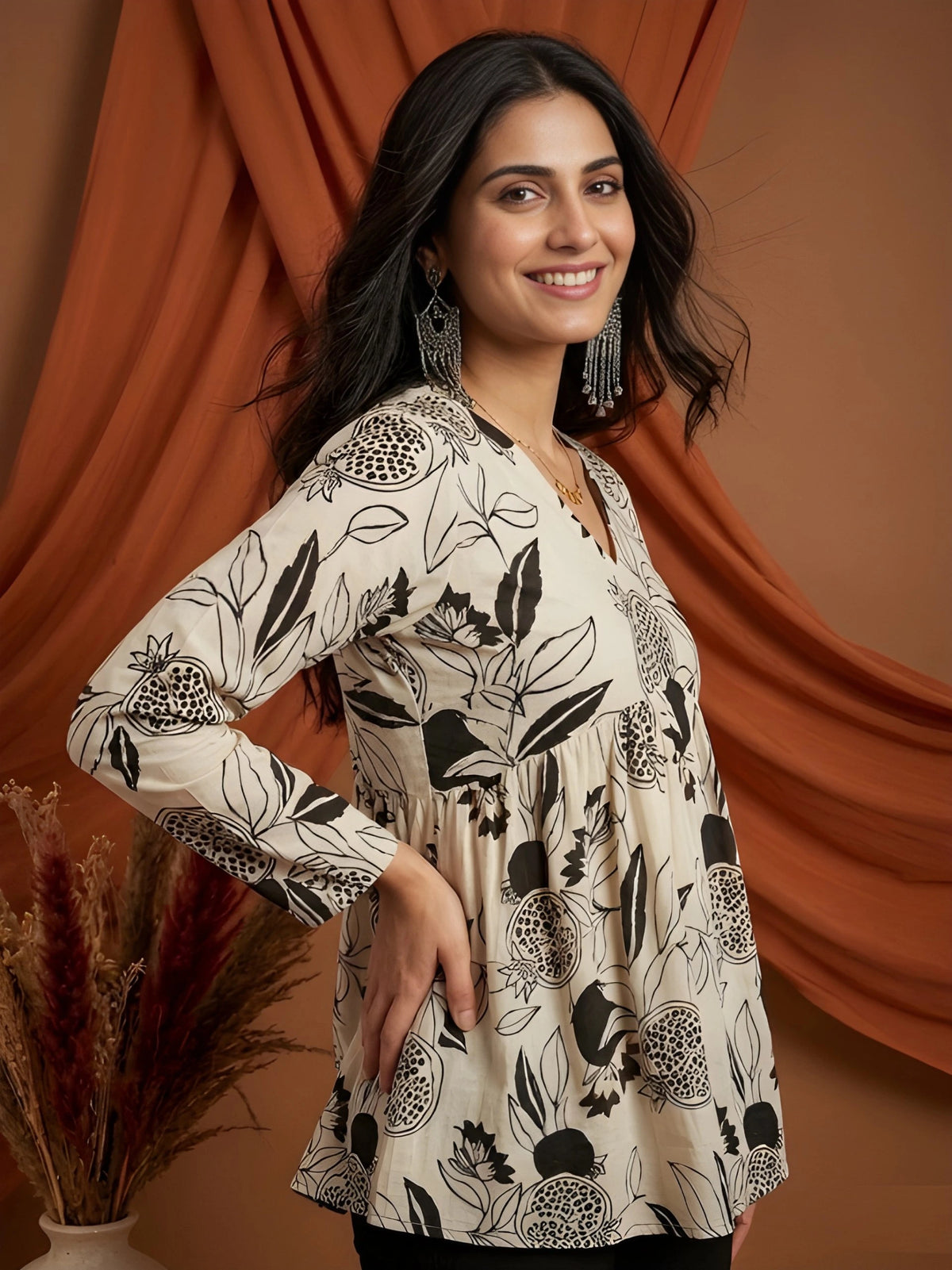 Woman wearing a floral patterned dress against an orange curtain background