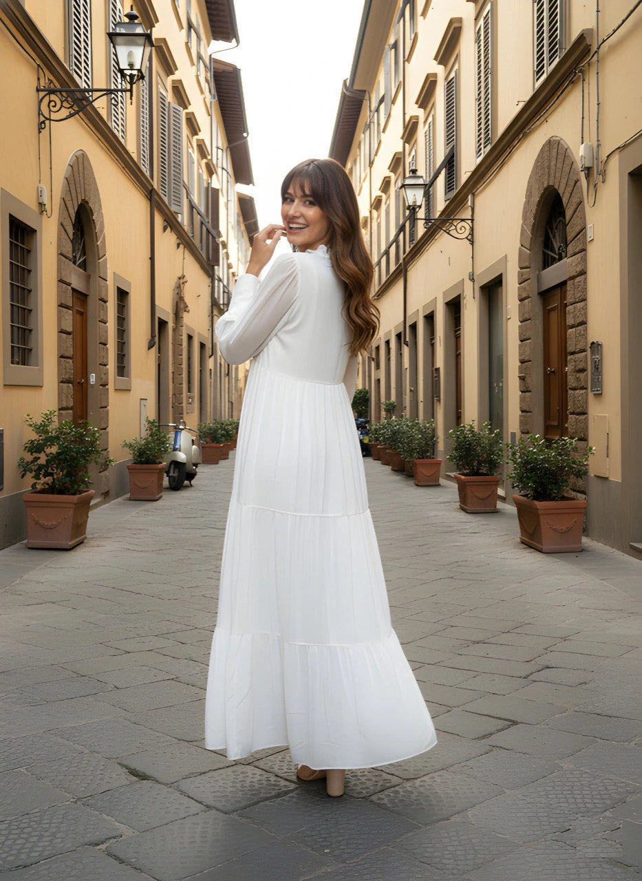Woman in a white dress standing on a narrow street with Italian architecture