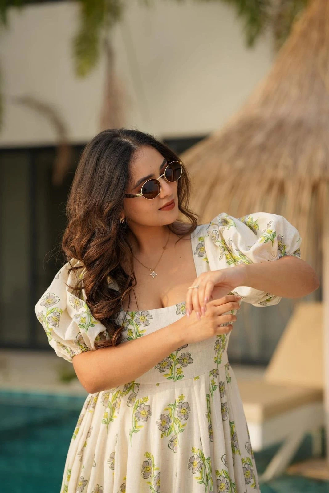 Woman in a floral dress standing outdoors with a blurred background