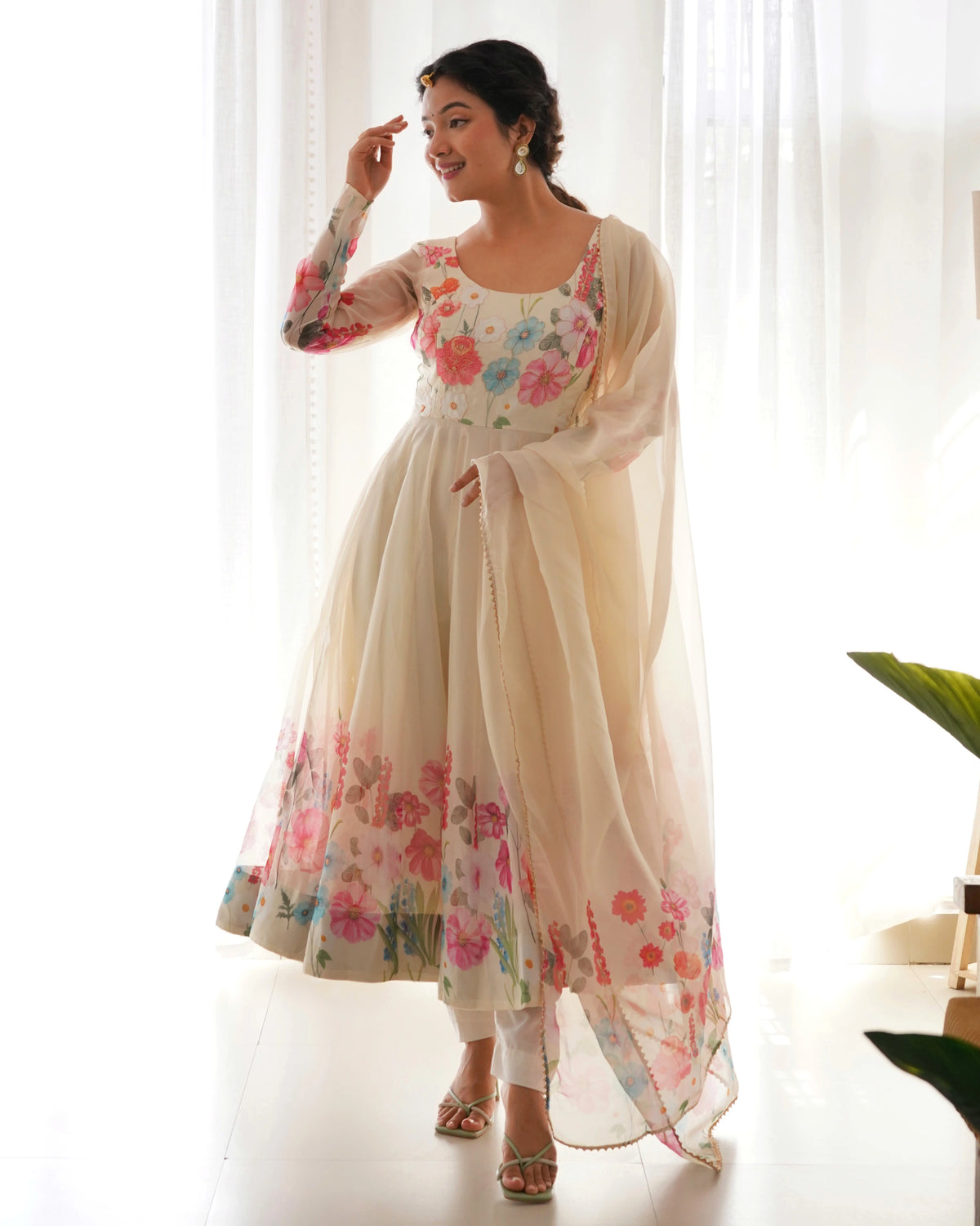 Woman wearing a floral dress with a sheer dupatta in a bright setting