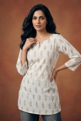 Woman wearing a white embroidered top against a brown background