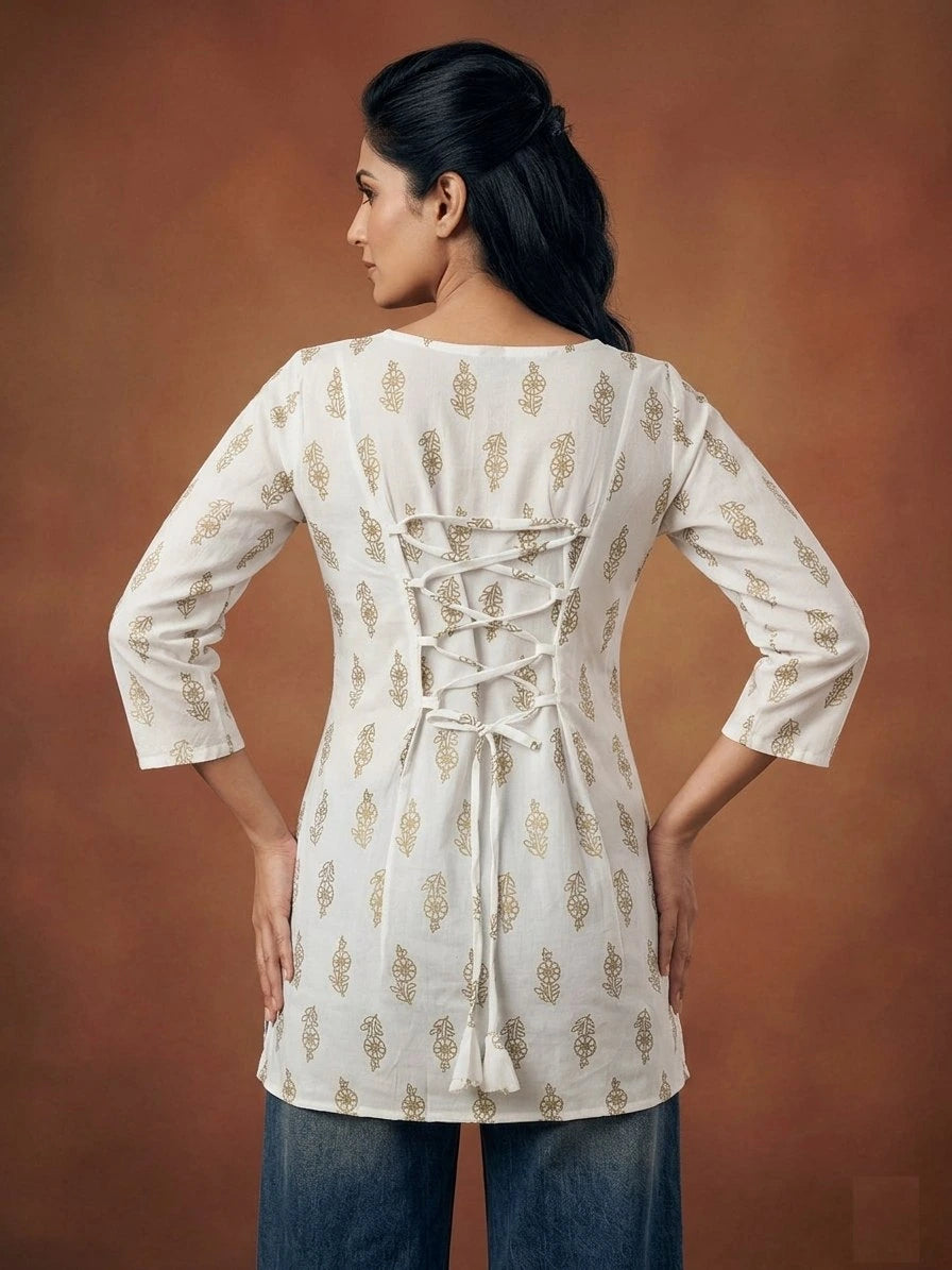 Woman wearing a white embroidered kurta with a brown background