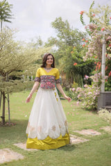 Designer White Lehenga Set featuring Mustard Yellow Embroidered Blouse, Multicolor Artisan Motifs, and Contrast Border