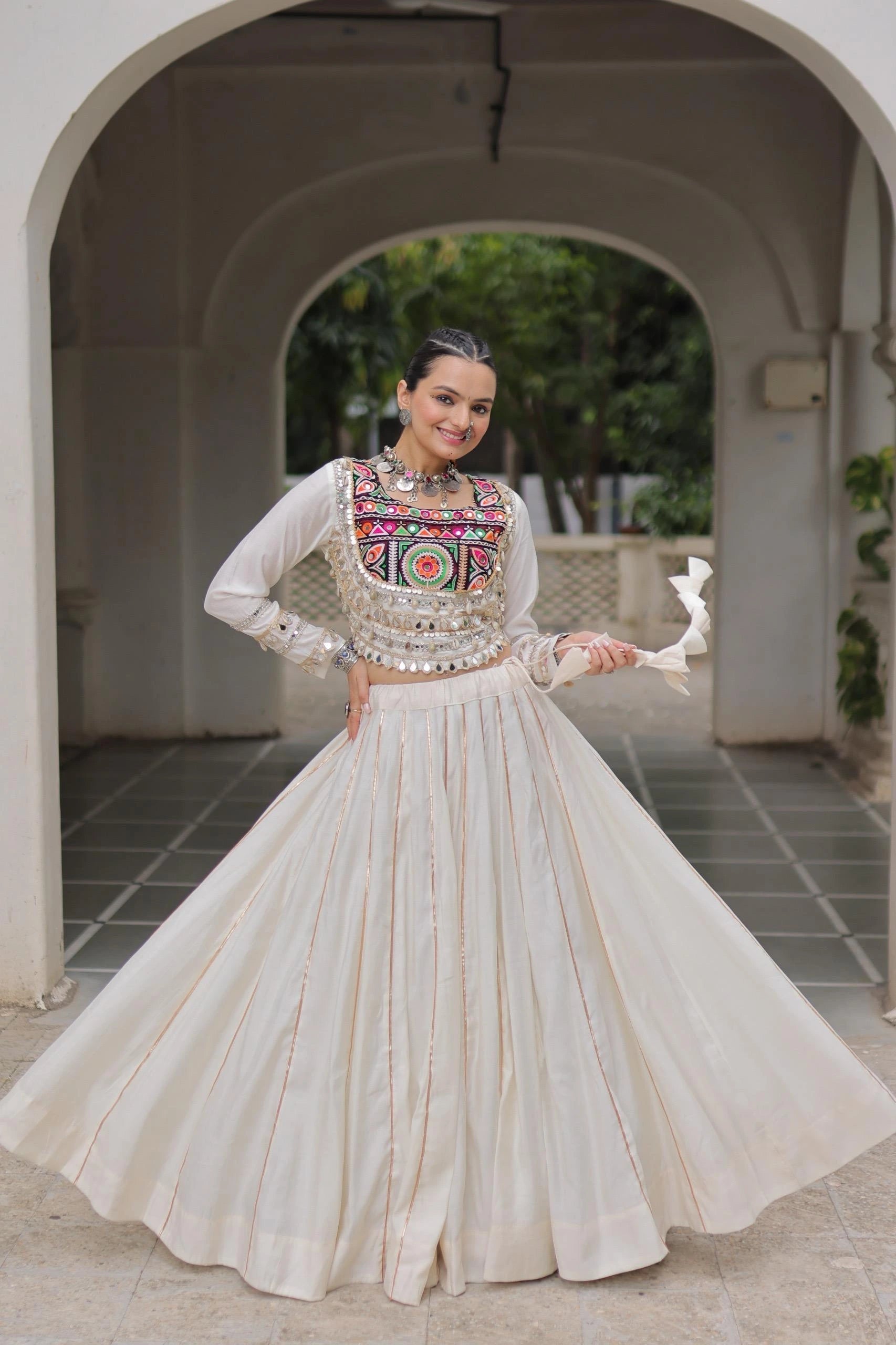 Woman in traditional outfit with intricate embroidery standing in a doorway.