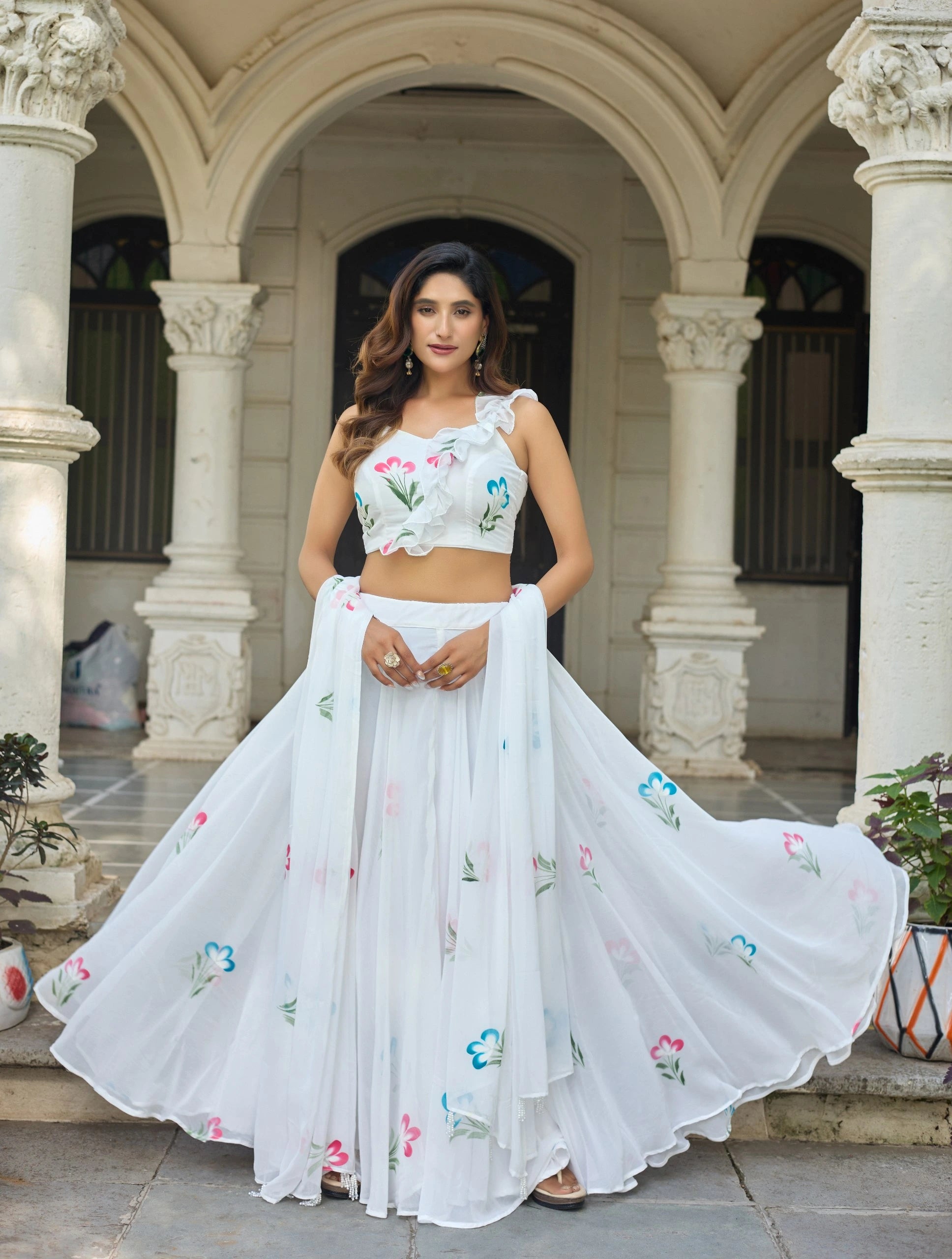 Woman in a white embroidered outfit standing in an architectural setting