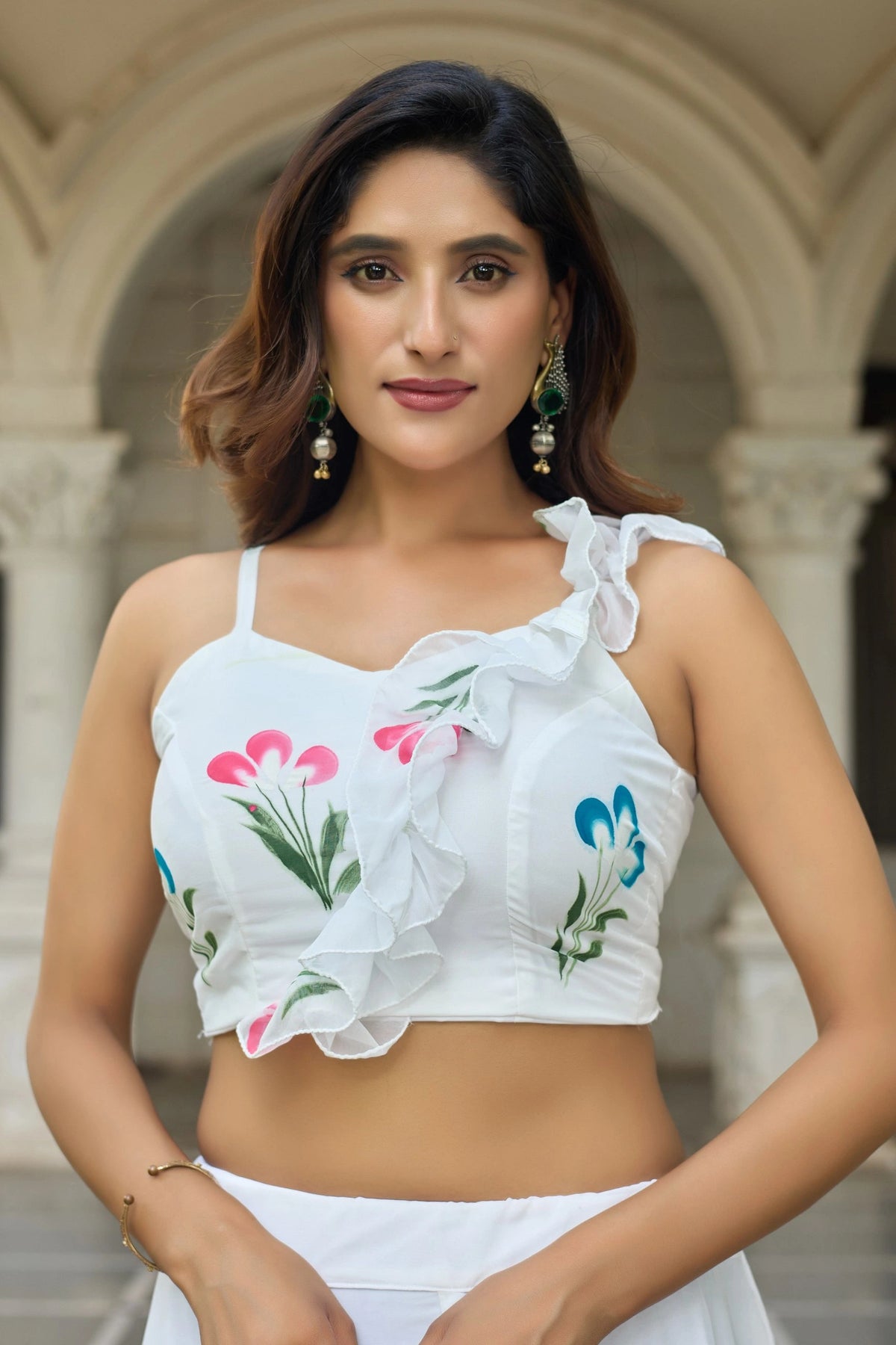 Woman wearing a white floral top in an outdoor setting