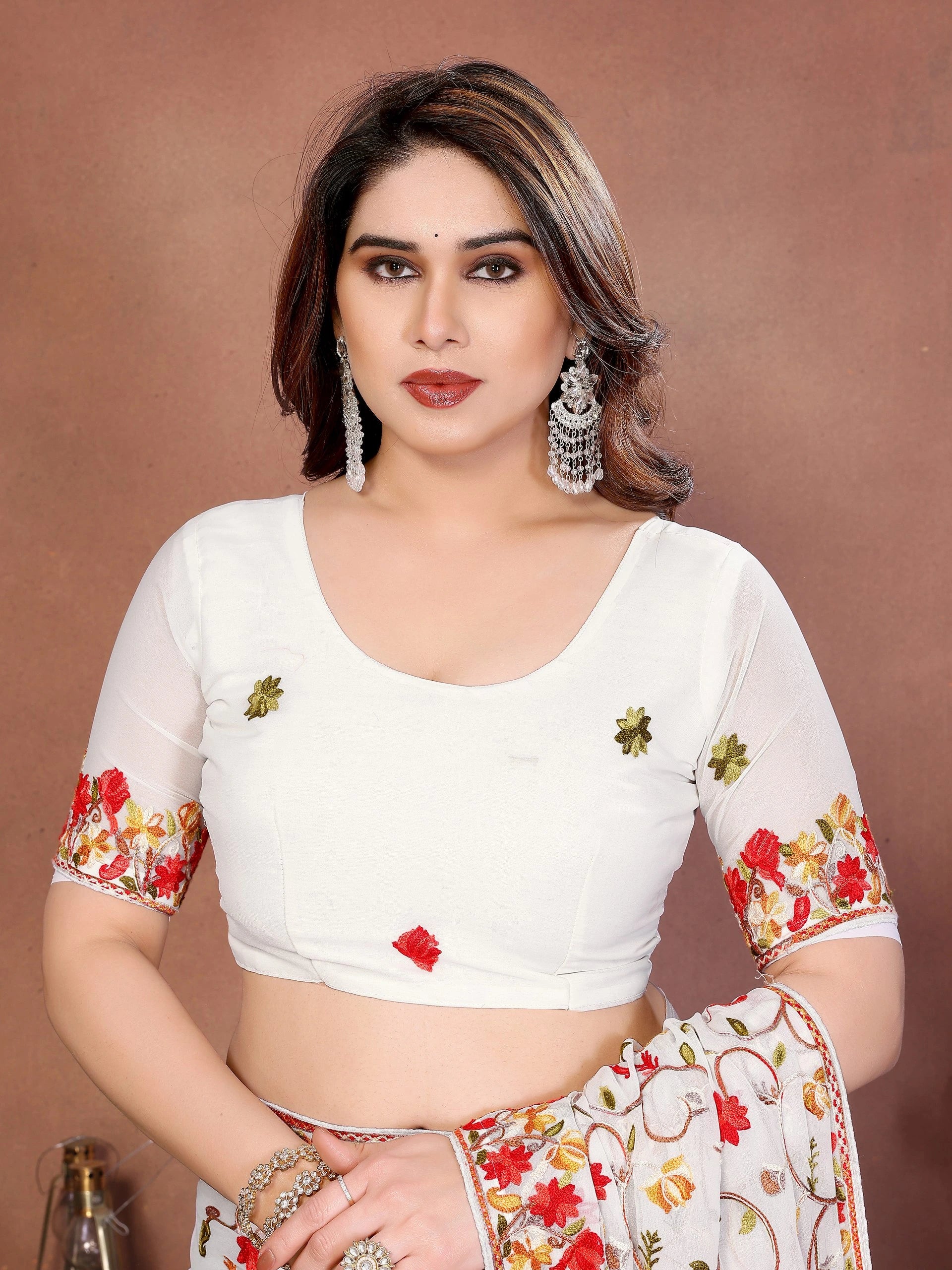 Woman wearing a white blouse with floral patterns on a brown background
