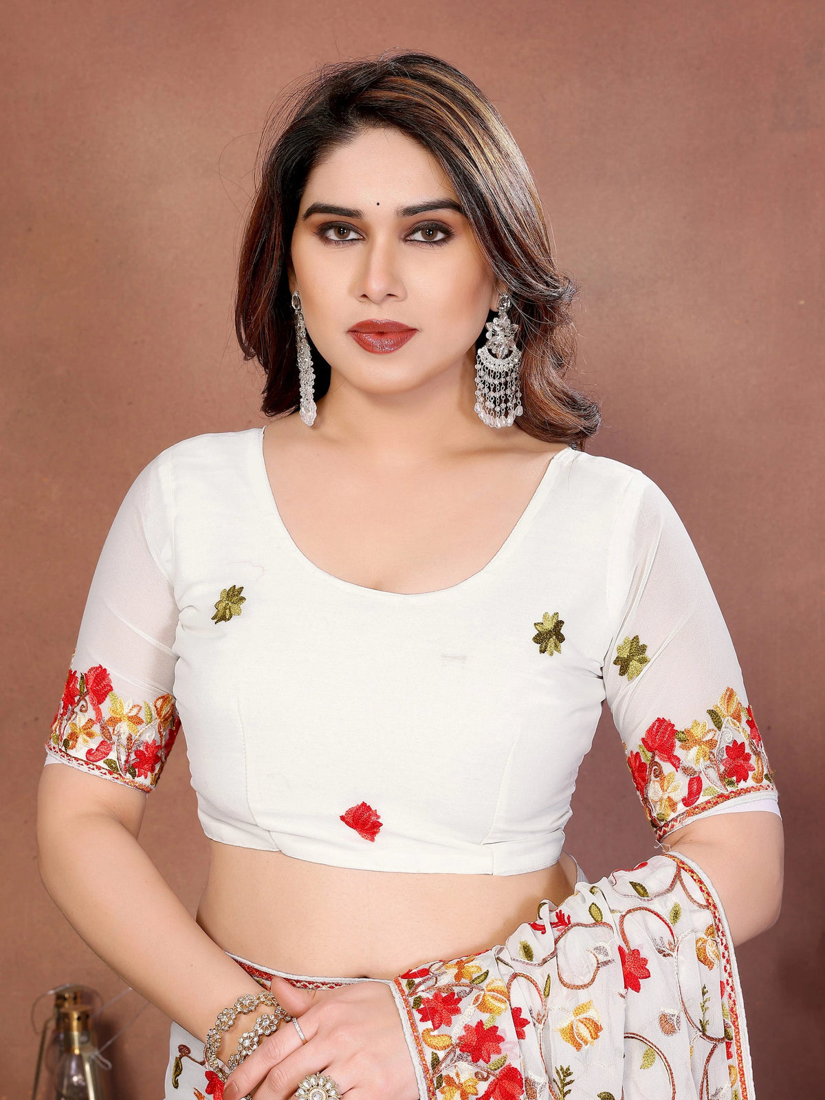 Woman wearing a white blouse with floral patterns on a brown background