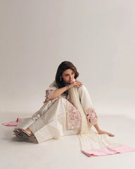 Woman in a traditional outfit with floral patterns on a plain background