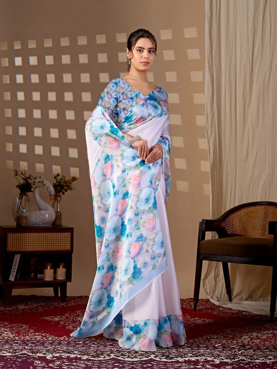 Woman wearing a floral saree in a room with a checkered wall and a chair.