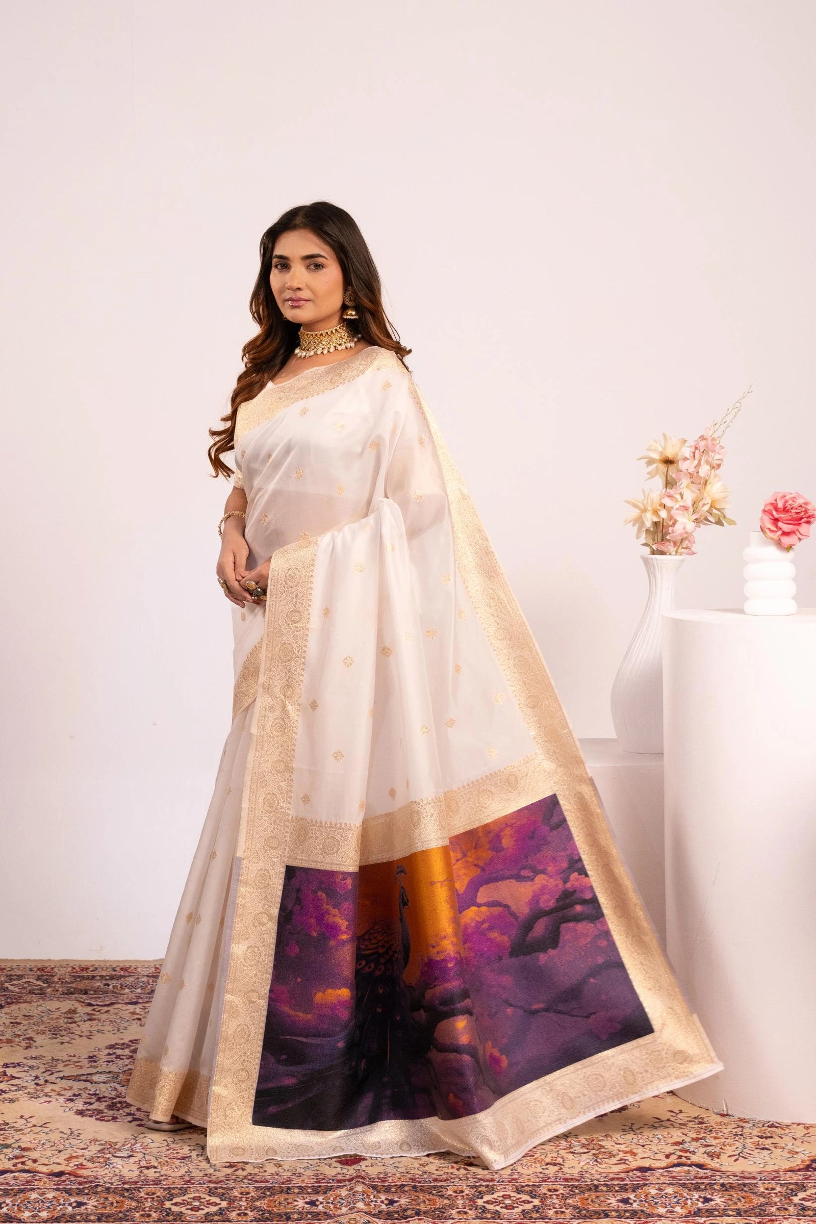 Woman wearing a red and beige saree with a white background