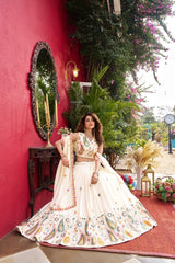 Woman in a traditional outfit standing in front of a red wall with decorative elements.