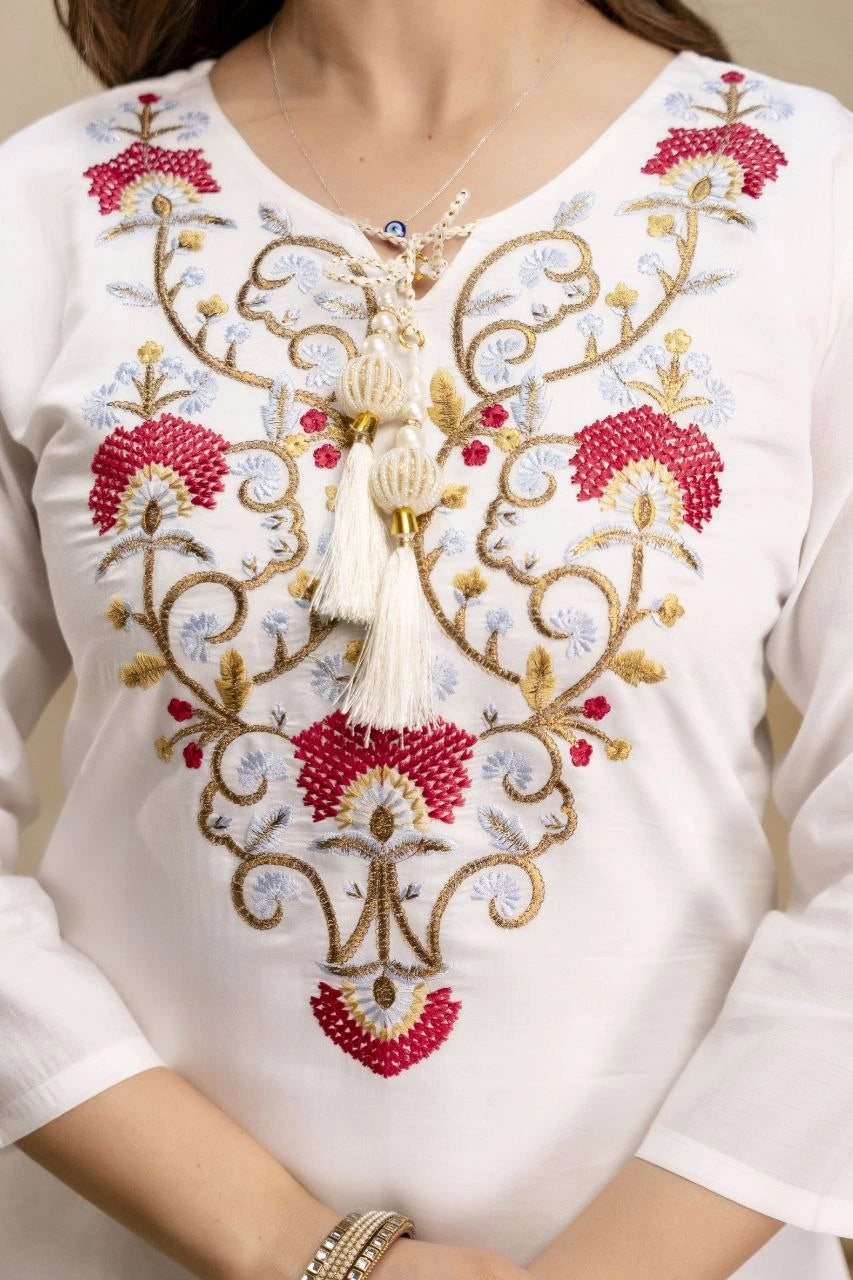 White blouse with intricate gold and red embroidery on a plain background