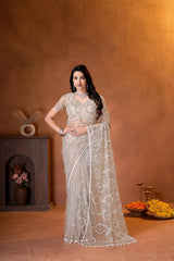 Elegant champagne beige designer saree featuring shimmering sequins embroidery and intricate handcrafted detailing for a graceful festive look.