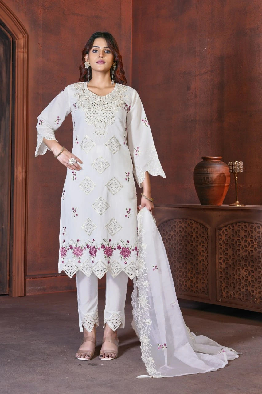 Woman wearing a white embroidered outfit with a brown background