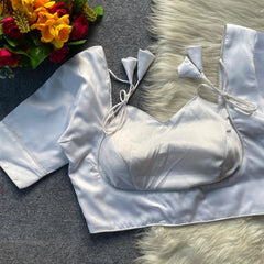 White satin bralette with matching shorts on a textured surface with flowers and fur.