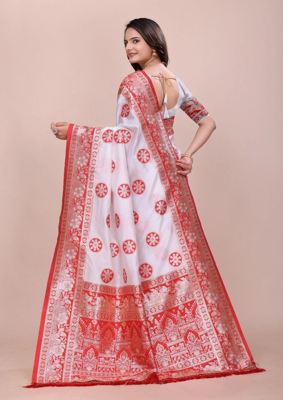 Woman wearing a white saree with red patterns on a beige background