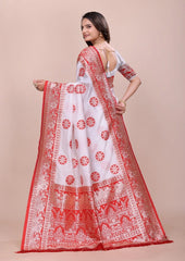 Woman wearing a white saree with red patterns on a beige background
