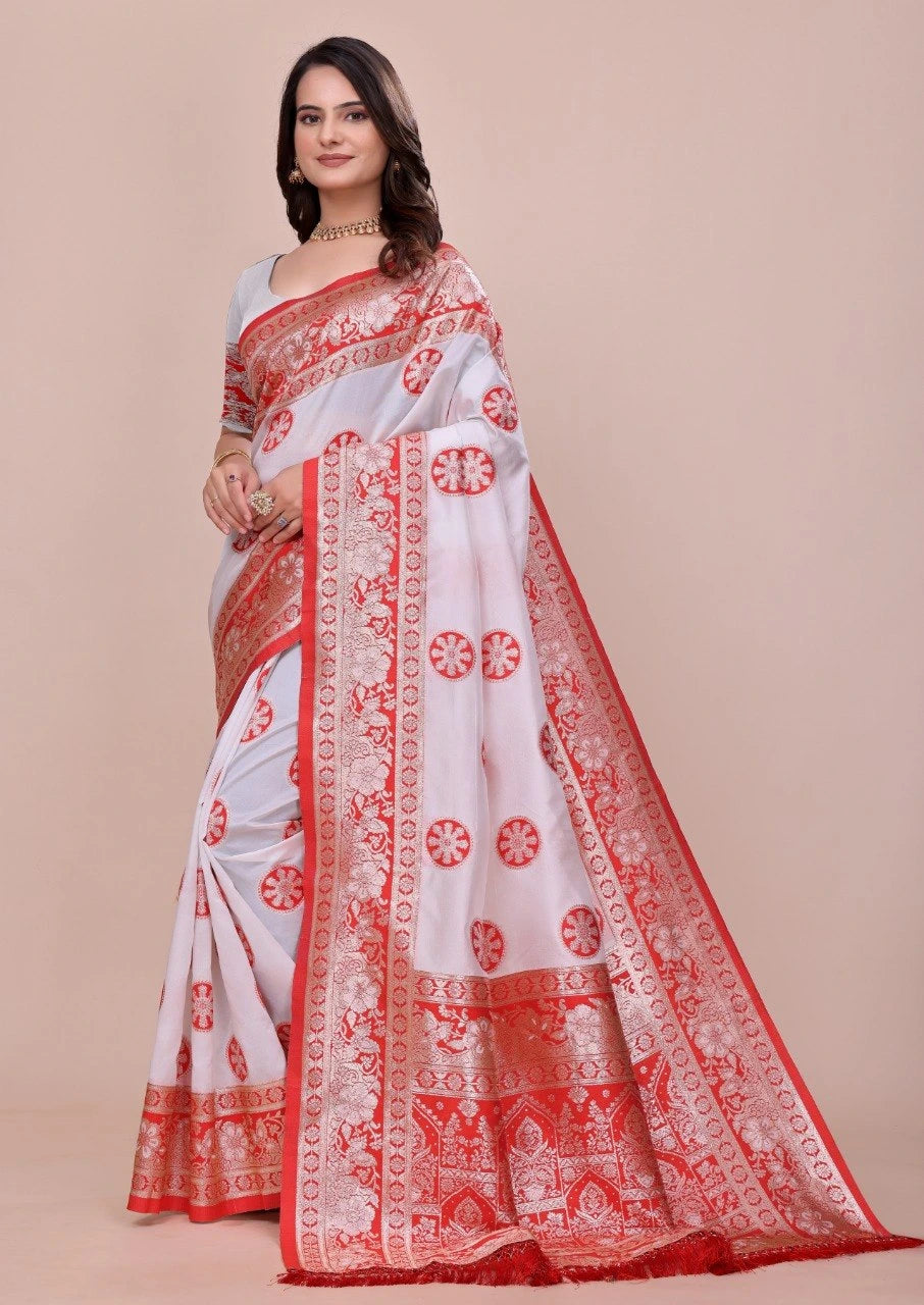 Woman wearing a white saree with red patterns on a beige background