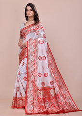 Woman wearing a white saree with red patterns on a beige background
