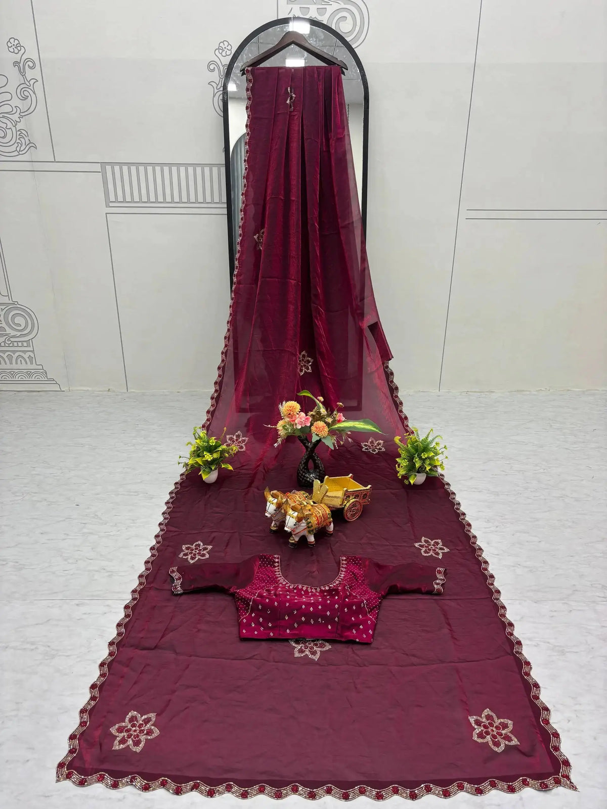Wine Diamond Work Saree flat lay with matching blouse piece on mirror stand