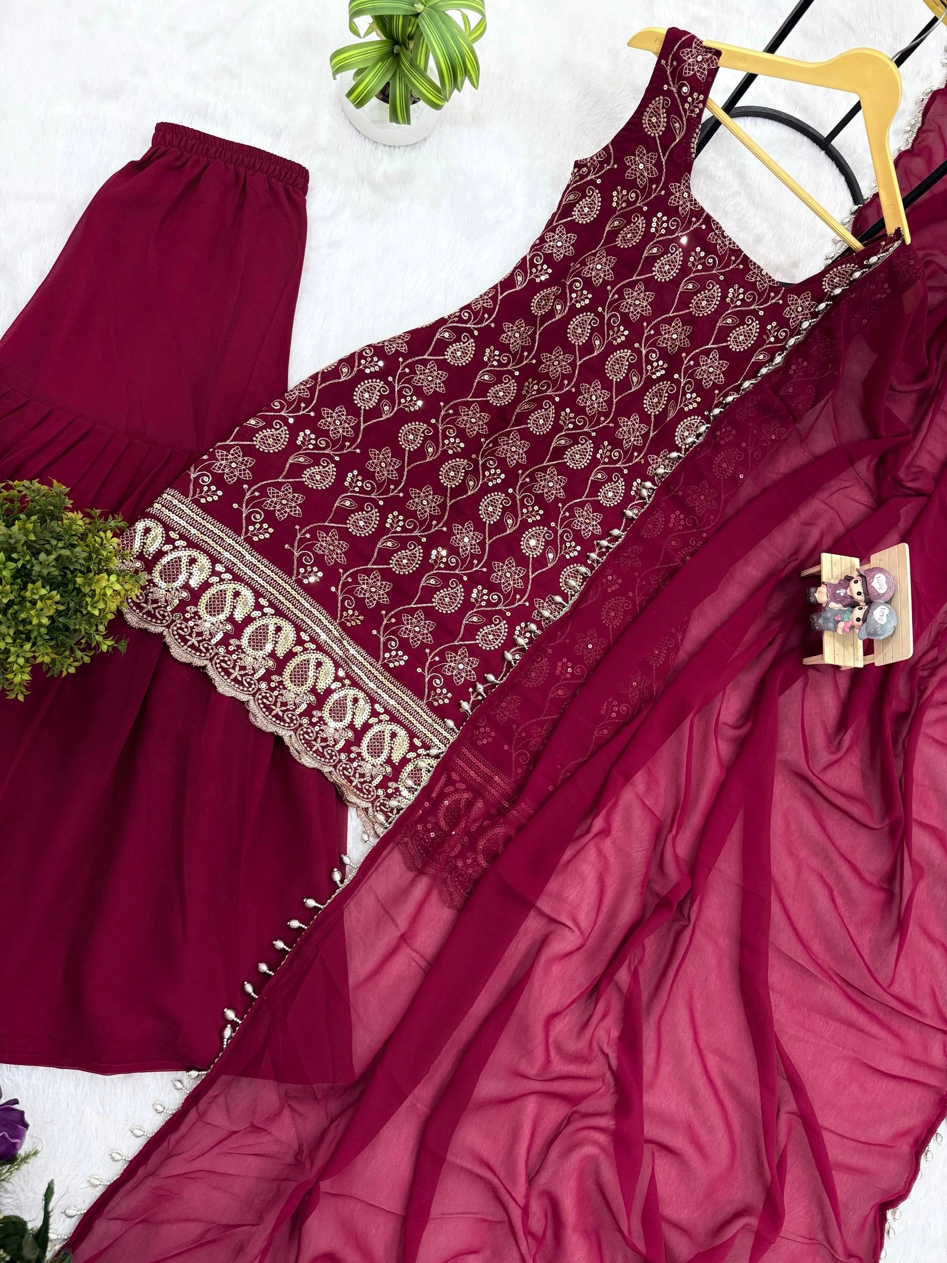 Maroon traditional outfit with floral embroidery on a white background