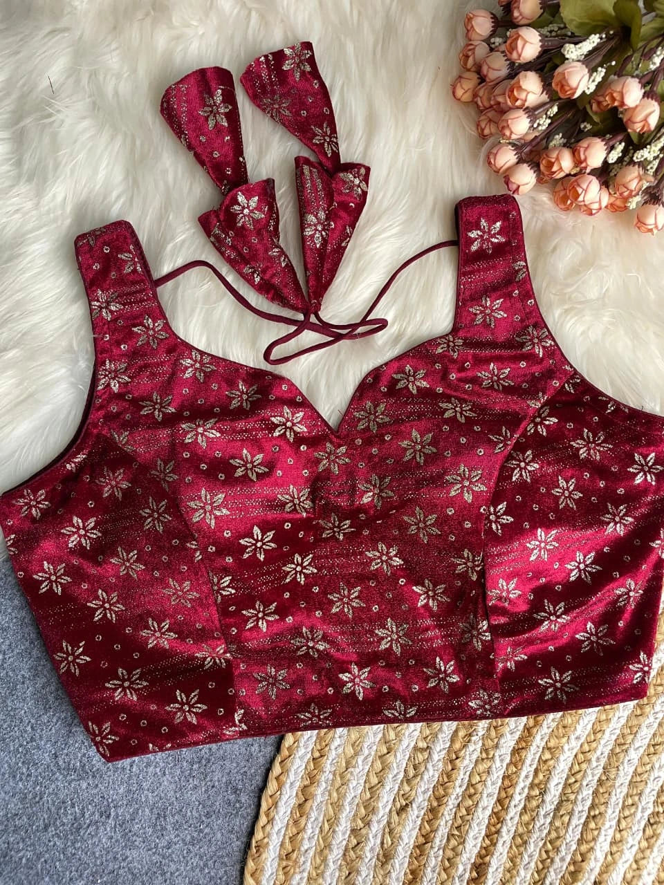 Red patterned top with matching hair accessories on a textured surface