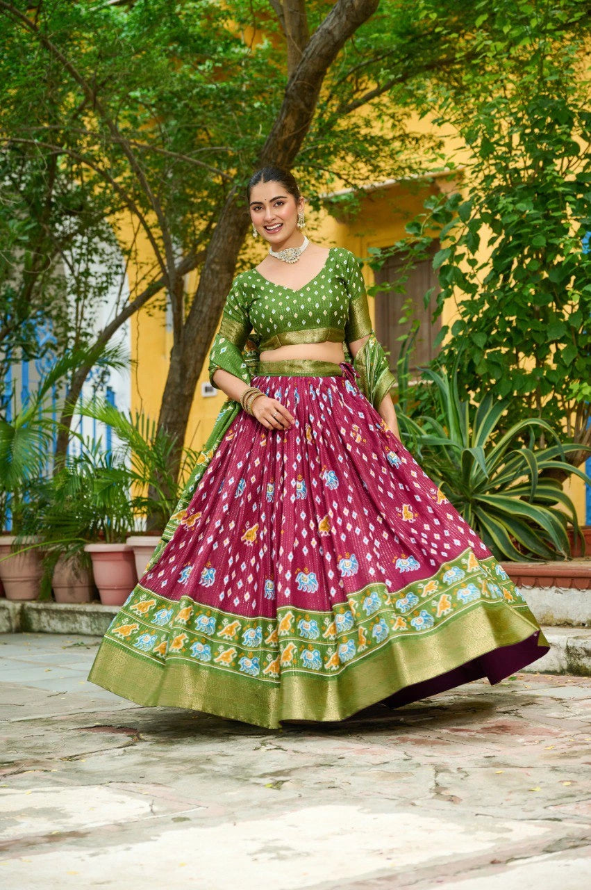 Woman in a traditional outfit standing outdoors with greenery around