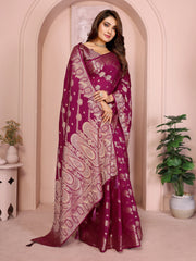 Woman wearing a purple saree with white patterns in an elegant indoor setting.