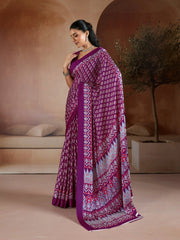 Woman wearing a purple saree with a pattern in an indoor setting