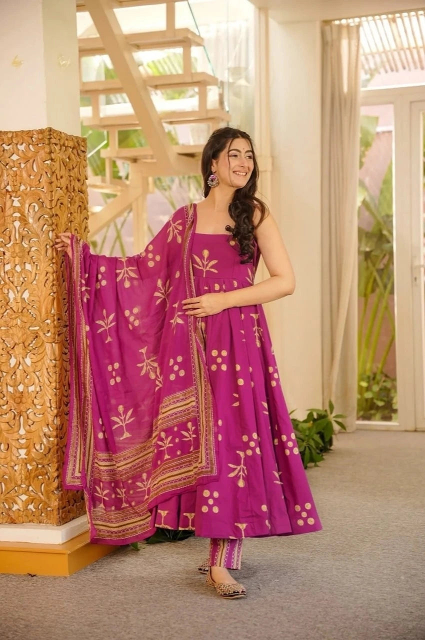 Woman in a purple traditional outfit with a matching dupatta in a well-lit room.