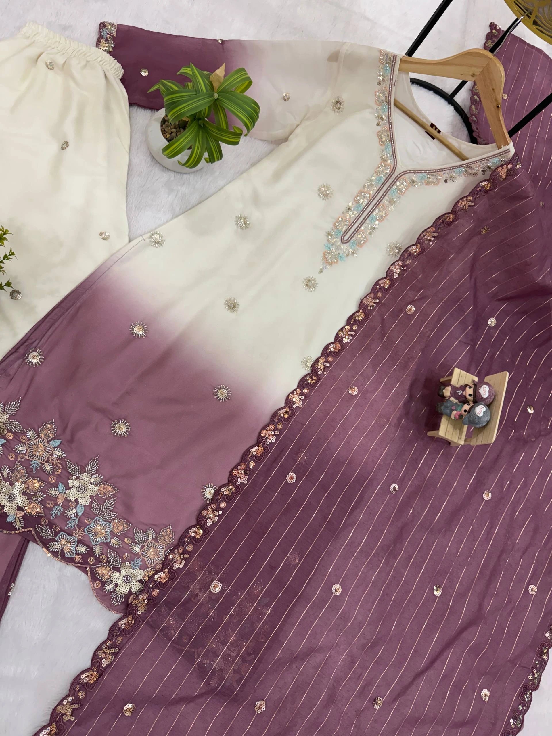 Gradient purple and white fabric with floral embroidery on a hanger.
