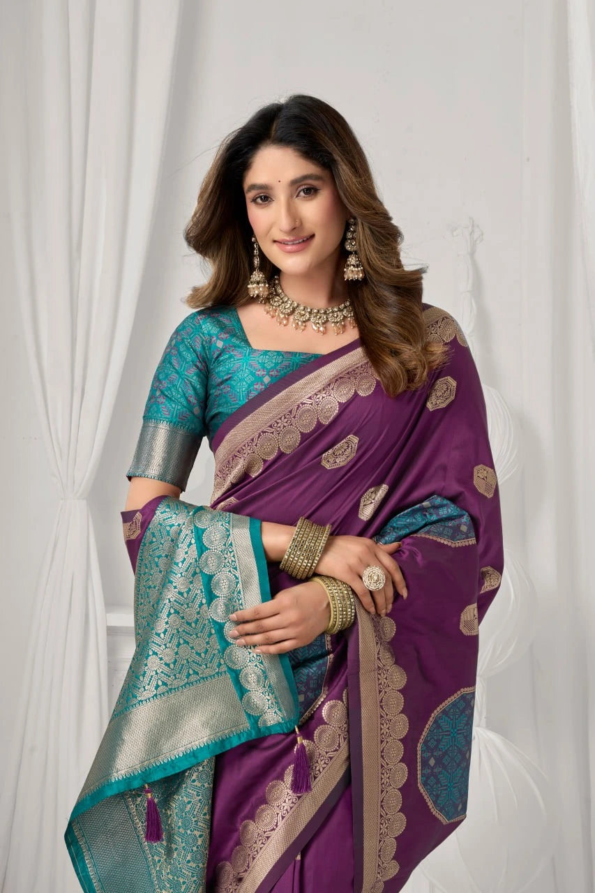 Woman wearing a purple and teal saree with gold patterns against a white background
