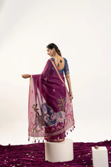 Woman wearing a purple saree with floral patterns on a white background