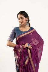 Woman wearing a purple saree with a blue blouse on a white background