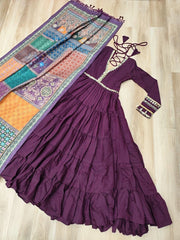 Purple dress with long sleeves and a colorful patterned fabric on a wooden floor.