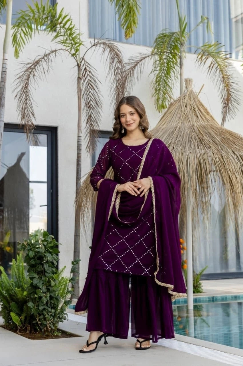 Woman in a purple traditional outfit standing in front of a modern building with palm trees.