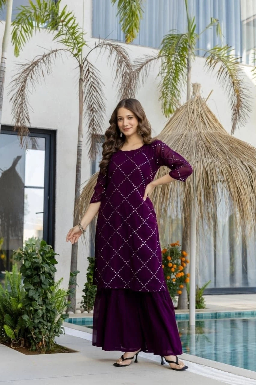 Woman in a purple traditional outfit standing in front of a pool with palm trees in the background